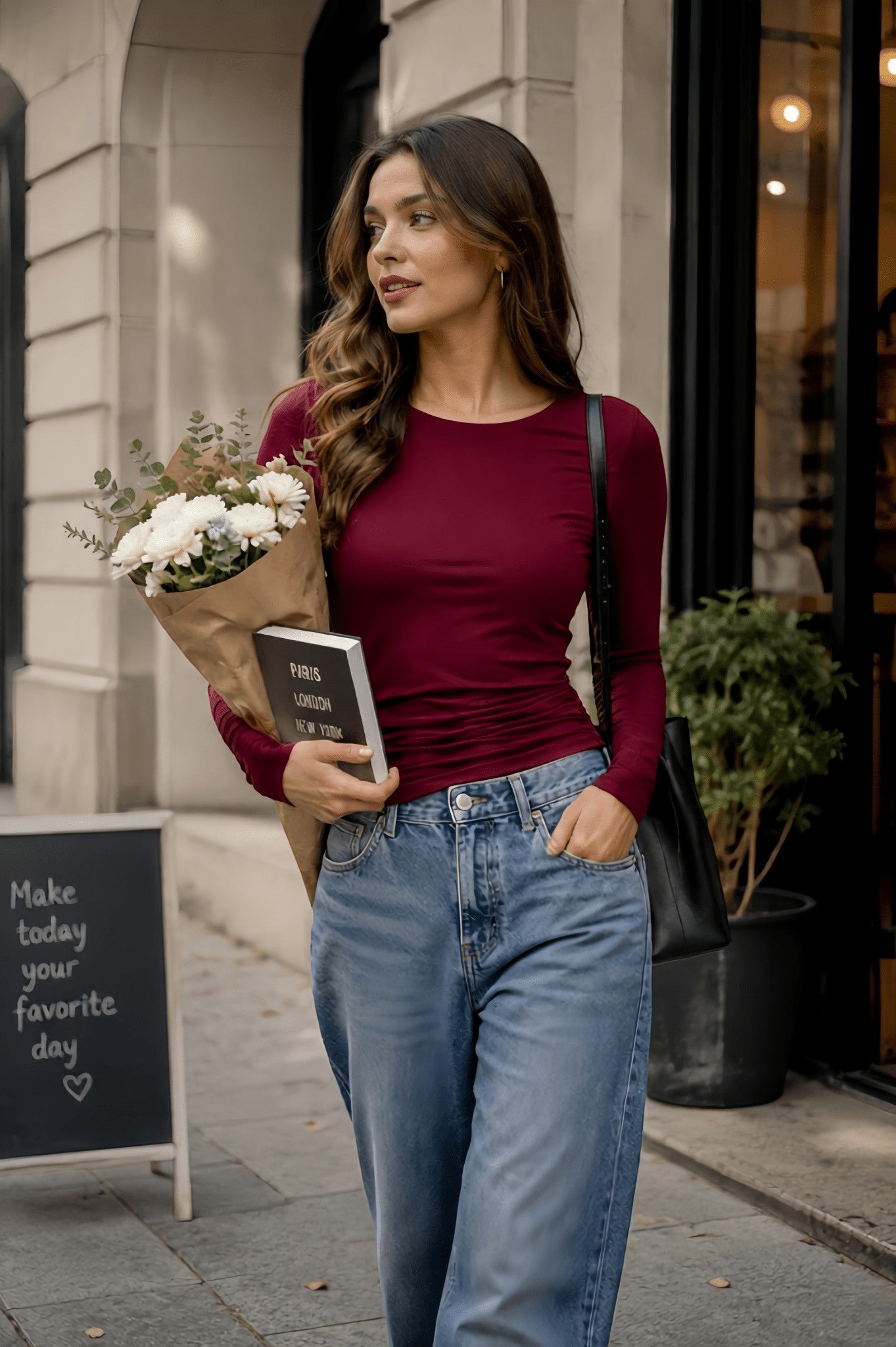 Modelo con top We Love Luana de manga larga color burdeos en doble licra, combinado con jeans y flores en la calle.